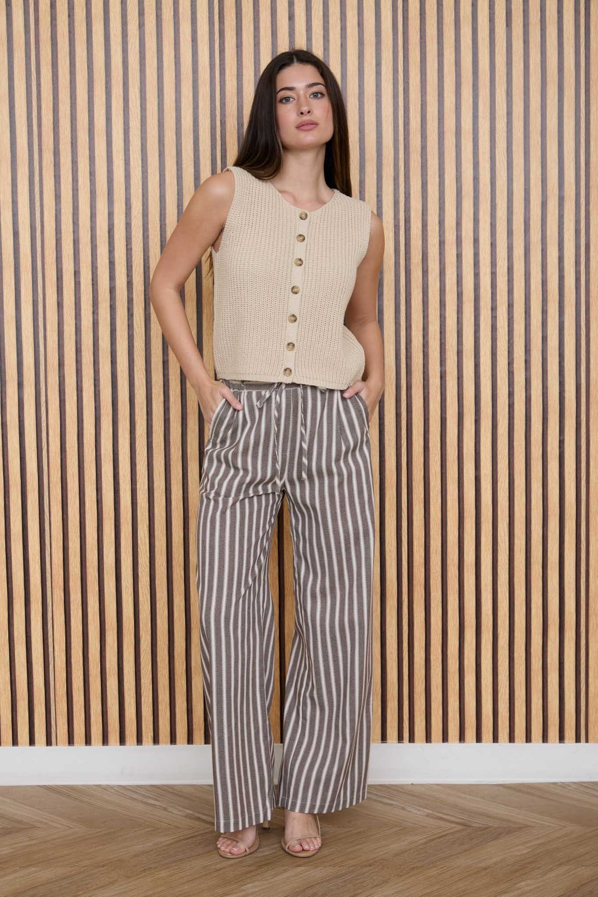 Beige sleeveless cardigan vest with front buttons and straight cropped fit