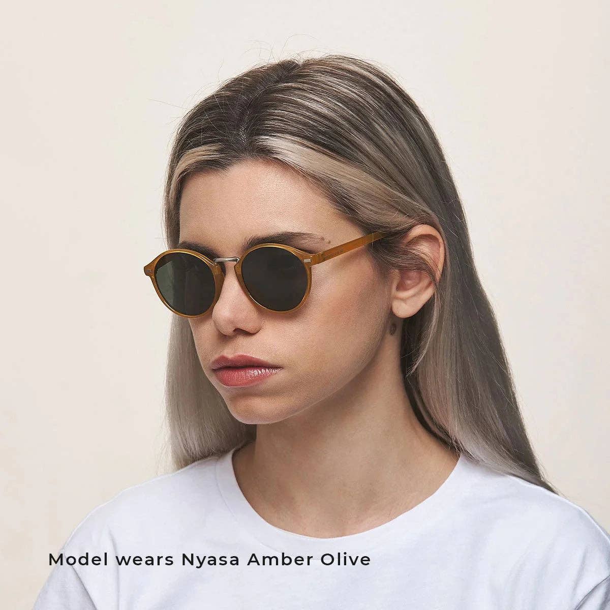 Amber olive round sunglasses with dark lenses, worn by model