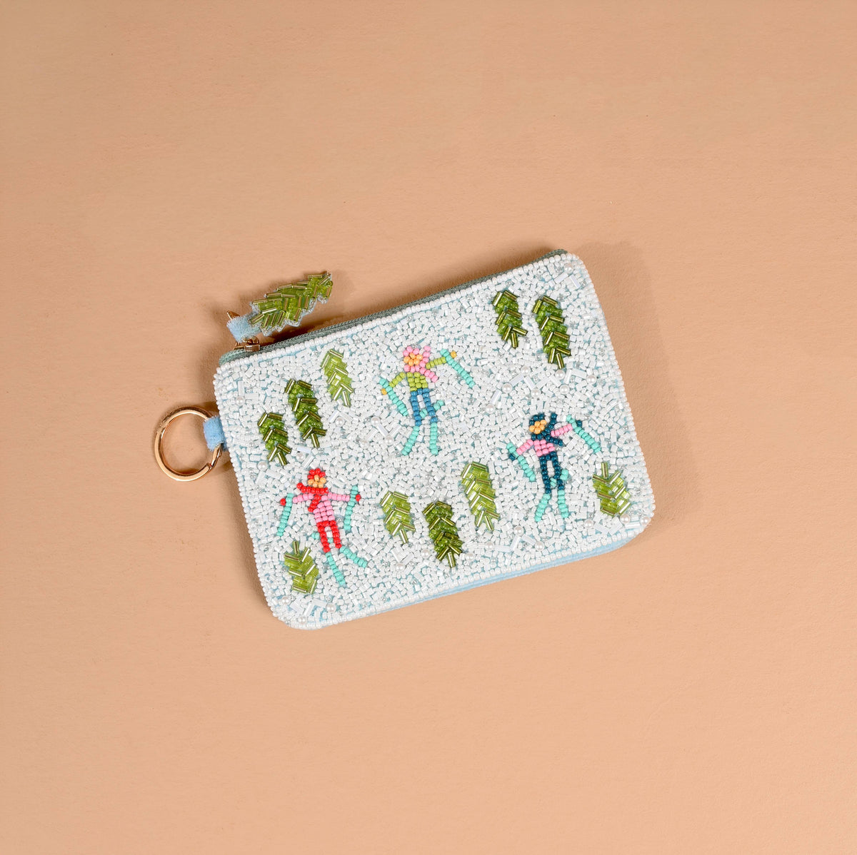 Beaded pouch keychain in light blue with skiing figures and pine-tree motifs