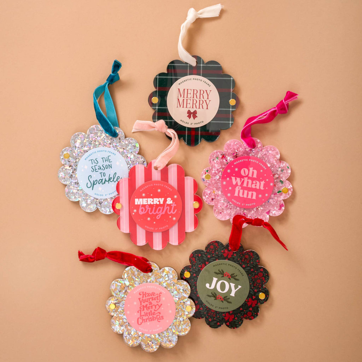 Assorted scalloped photo frame ornaments with ribbons, including evergreen plaid and glitter designs