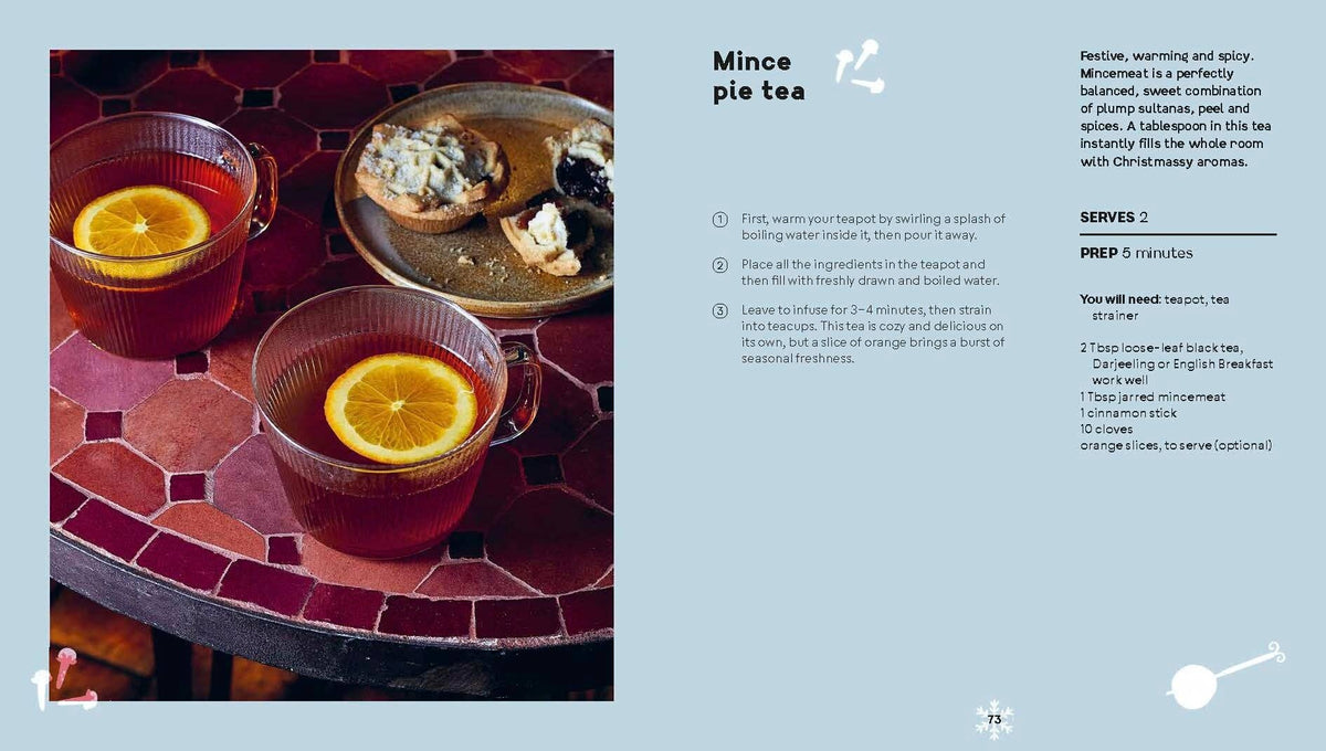 Mulled tea in red mugs with orange slices on a tiled tray