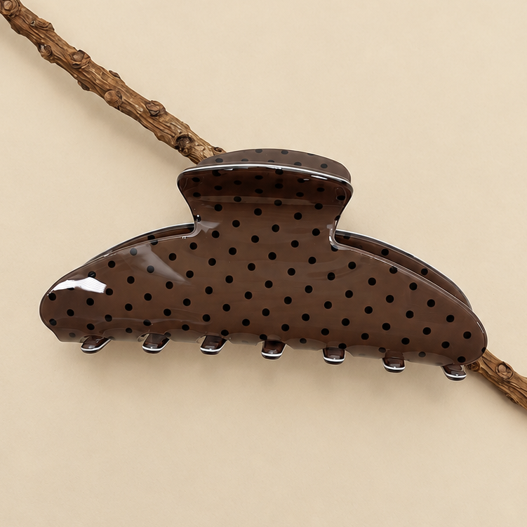 Dark brown oval jumbo hair claw clip with black polka dots and silver teeth.