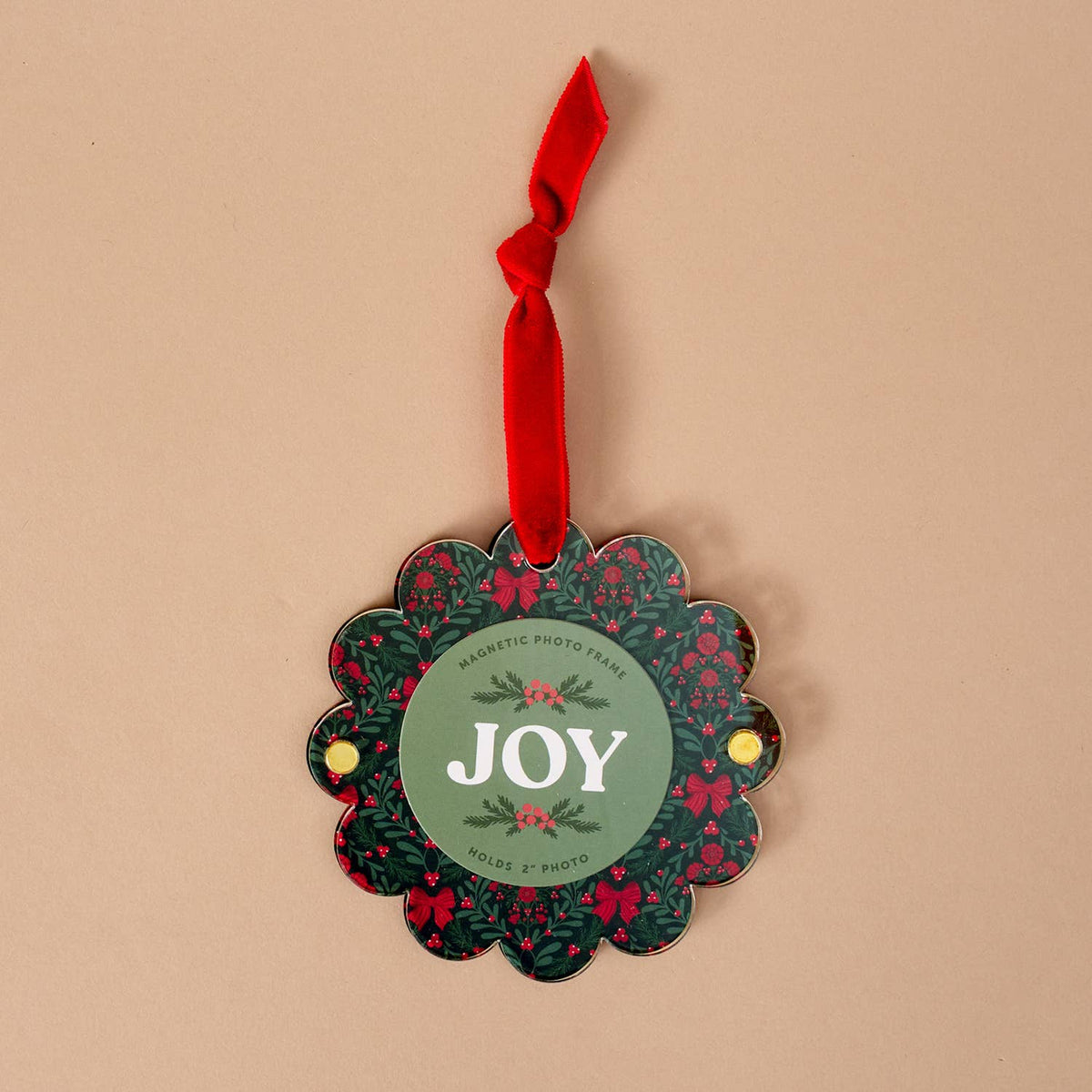 Scalloped round picture frame ornament with red ribbon, 'JOY' text on green floral design