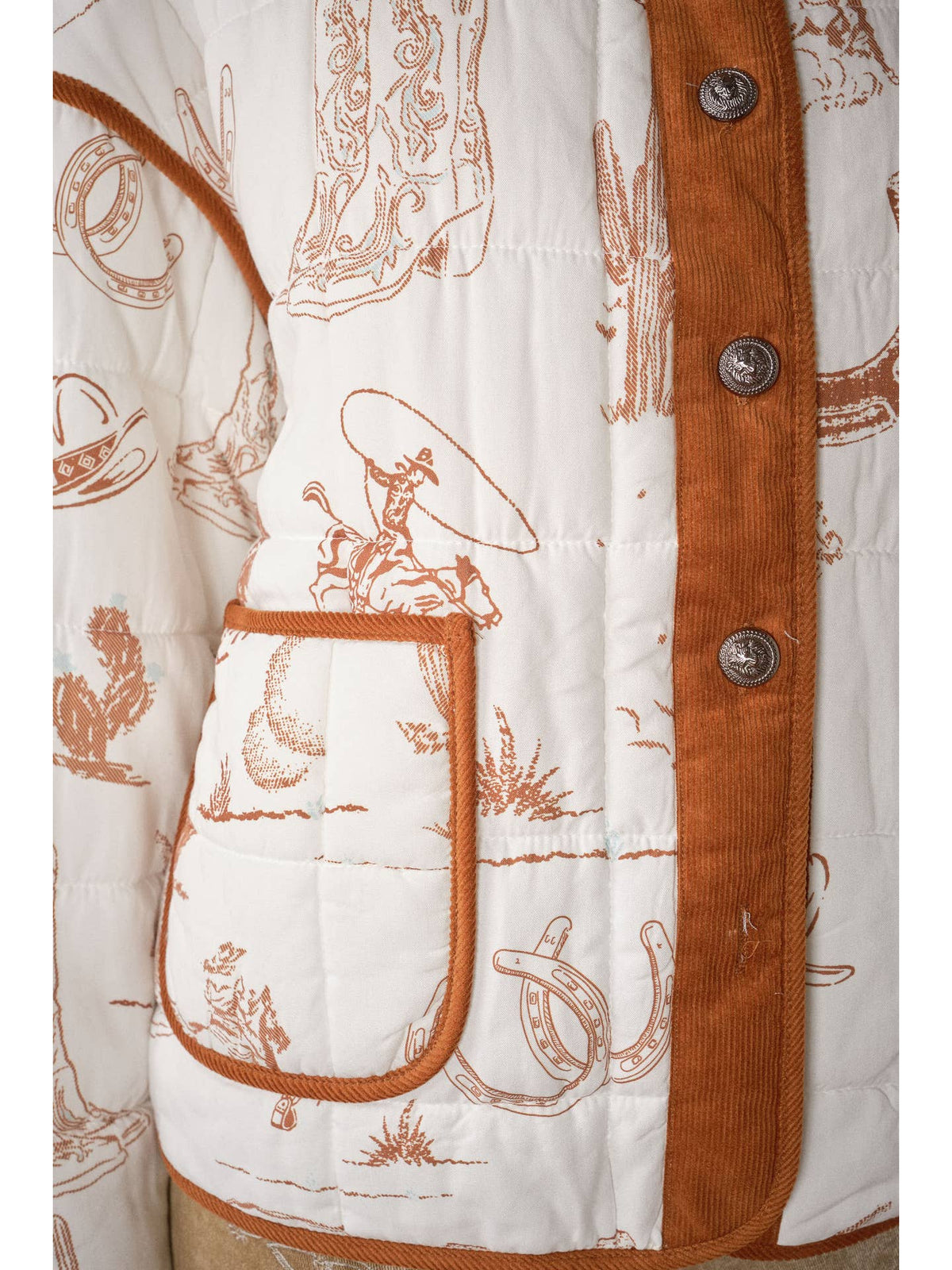 Western quilted jacket close-up: brown-trimmed pocket and western print on white quilted fabric