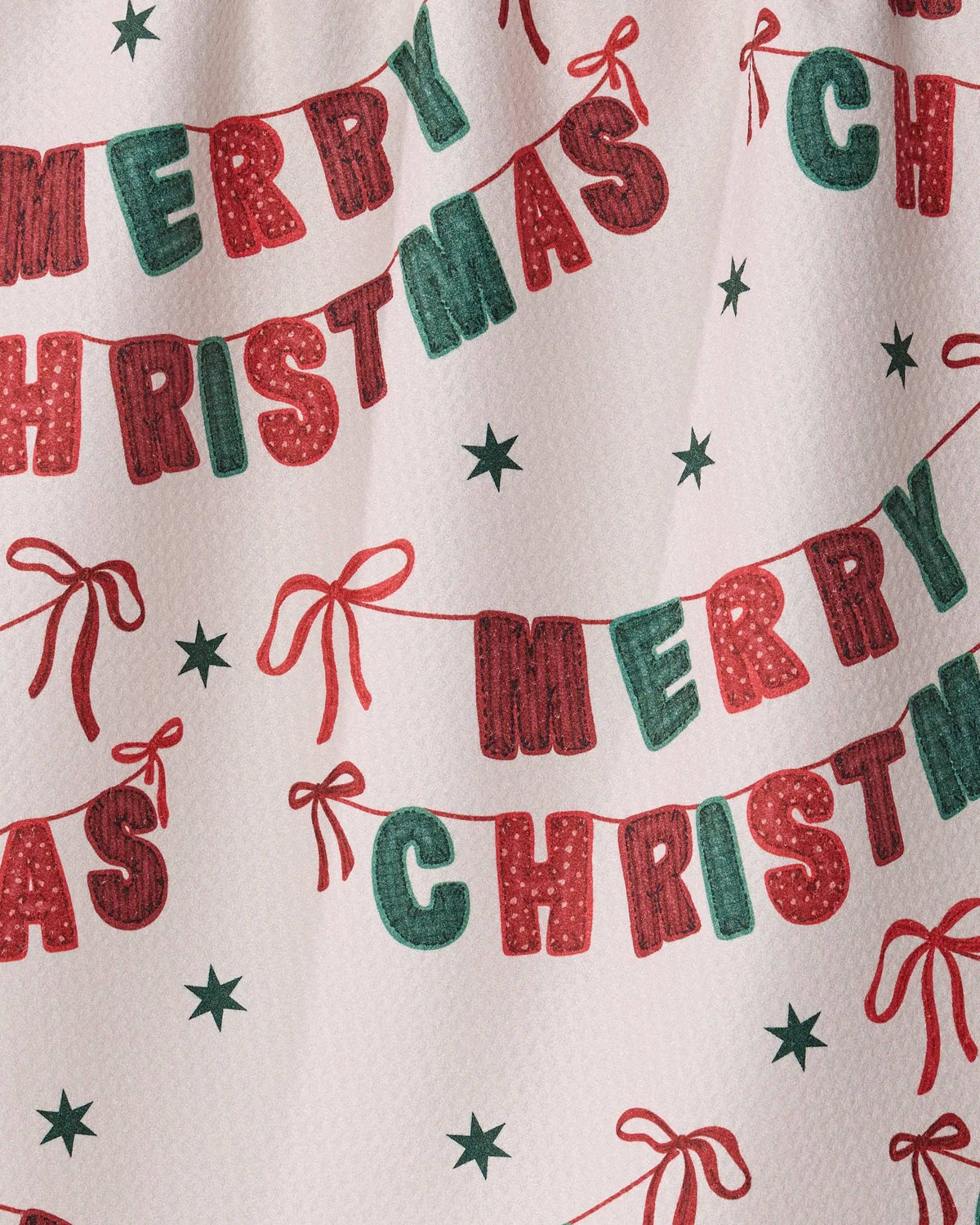 Close-up Christmas banner tea towel fabric with Merry Christmas text and ribbon bows