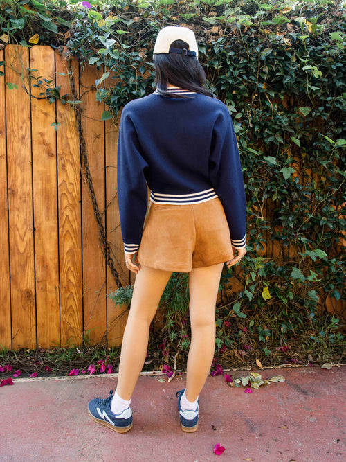 Tan faux suede shorts with pleated front and mid-rise fit, back view