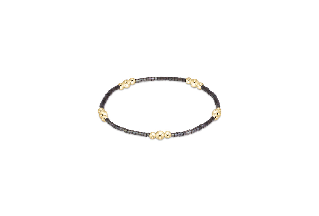 Beaded gold-tone bracelet with dark gray beads and round gold accents