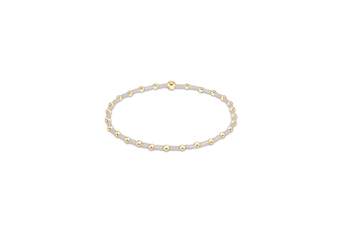 Gold-tone beaded bracelet with small white round beads