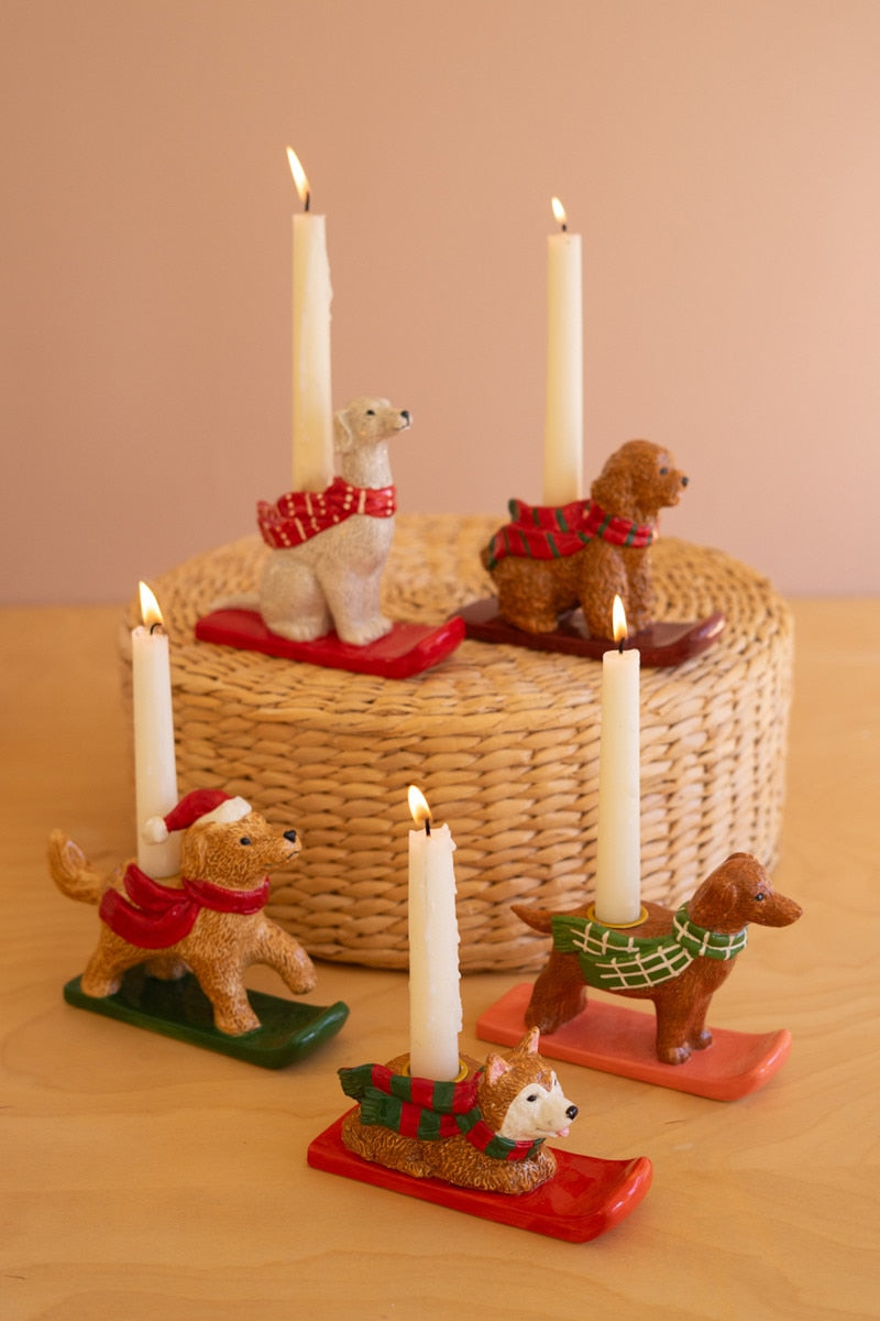 Ceramic dog taper candle holder set on woven tray with red-and-green holiday scarves