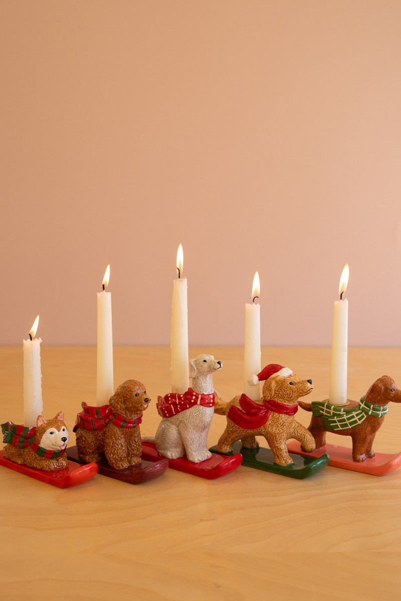 Ceramic dog taper candle holder lineup with several taper candles and holiday scarves