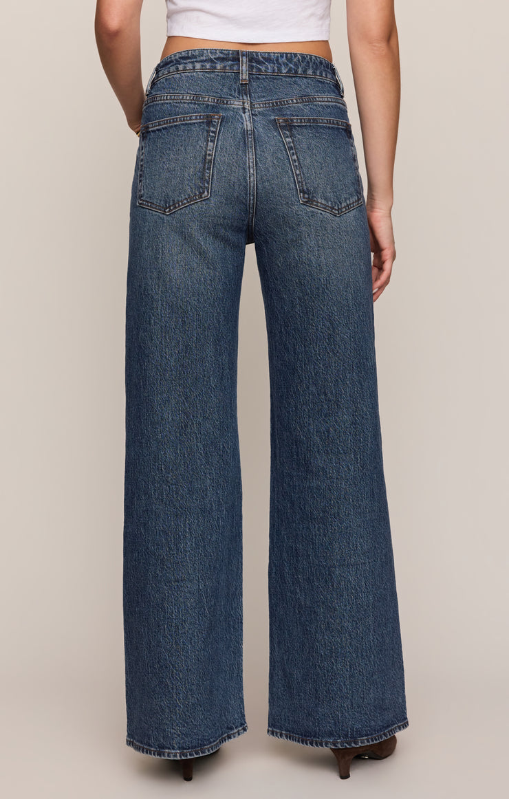 Women's mid-rise wide-leg jeans, back view with yoke, two back pockets, belt loops.