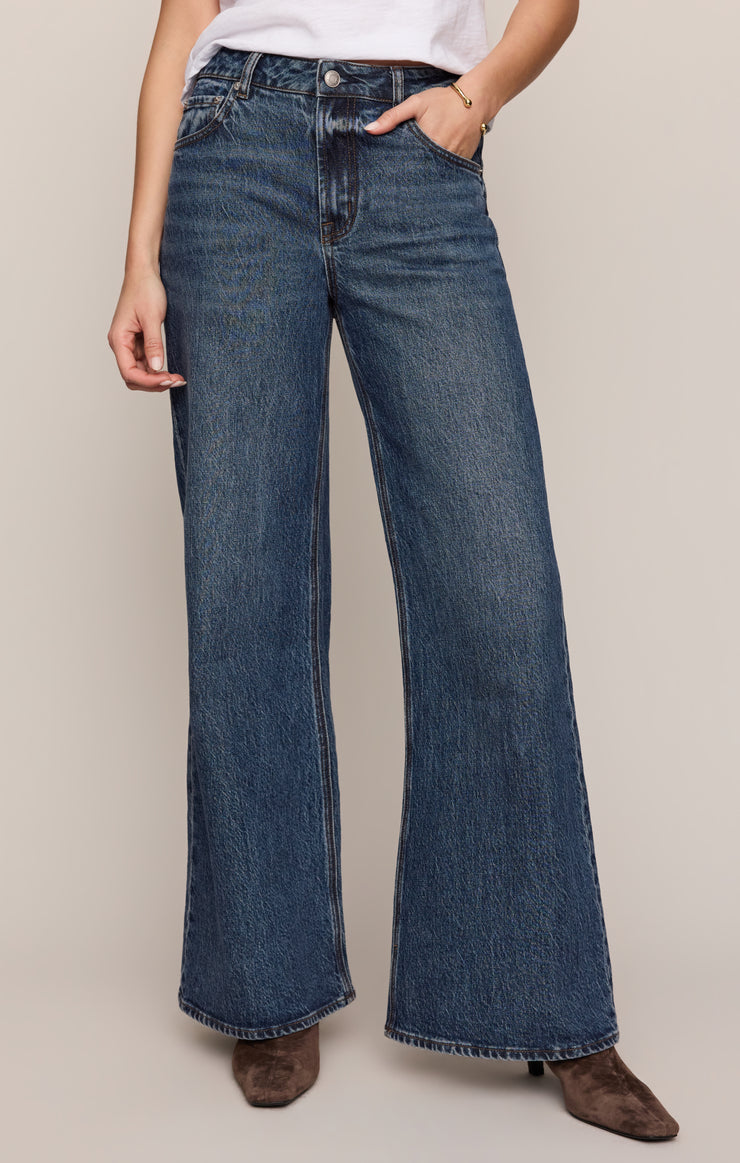 Women's mid-rise wide-leg jeans in dark blue wash, button fly, belt loops, side pockets.