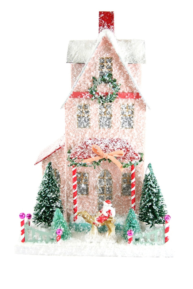 Christmas house decoration with miniature trees, presents, and candy-cane roof
