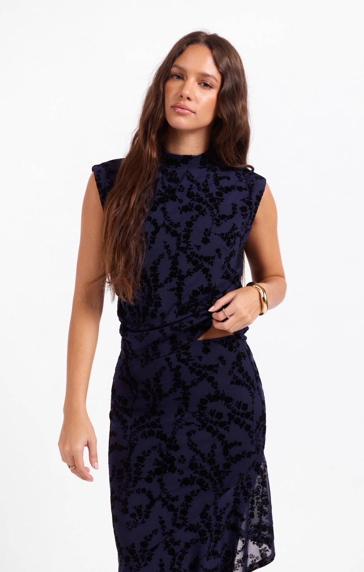 Dark navy sleeveless high-neck mesh top with tonal floral pattern and side drape
