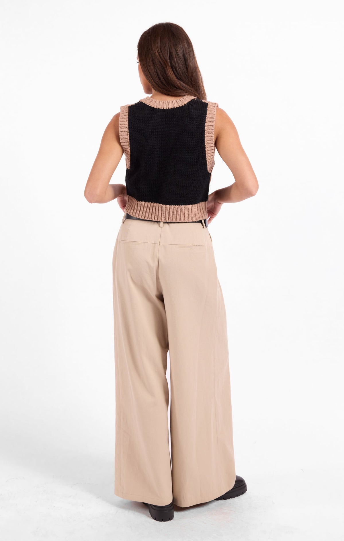 Black knit sweater vest back view with beige ribbed V-neck and hem
