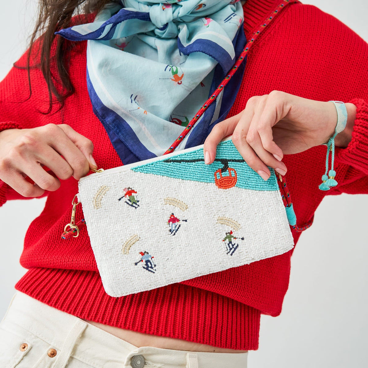 Embroidered white clutch with ski motifs, turquoise trim, colorful beaded strap, gold hardware