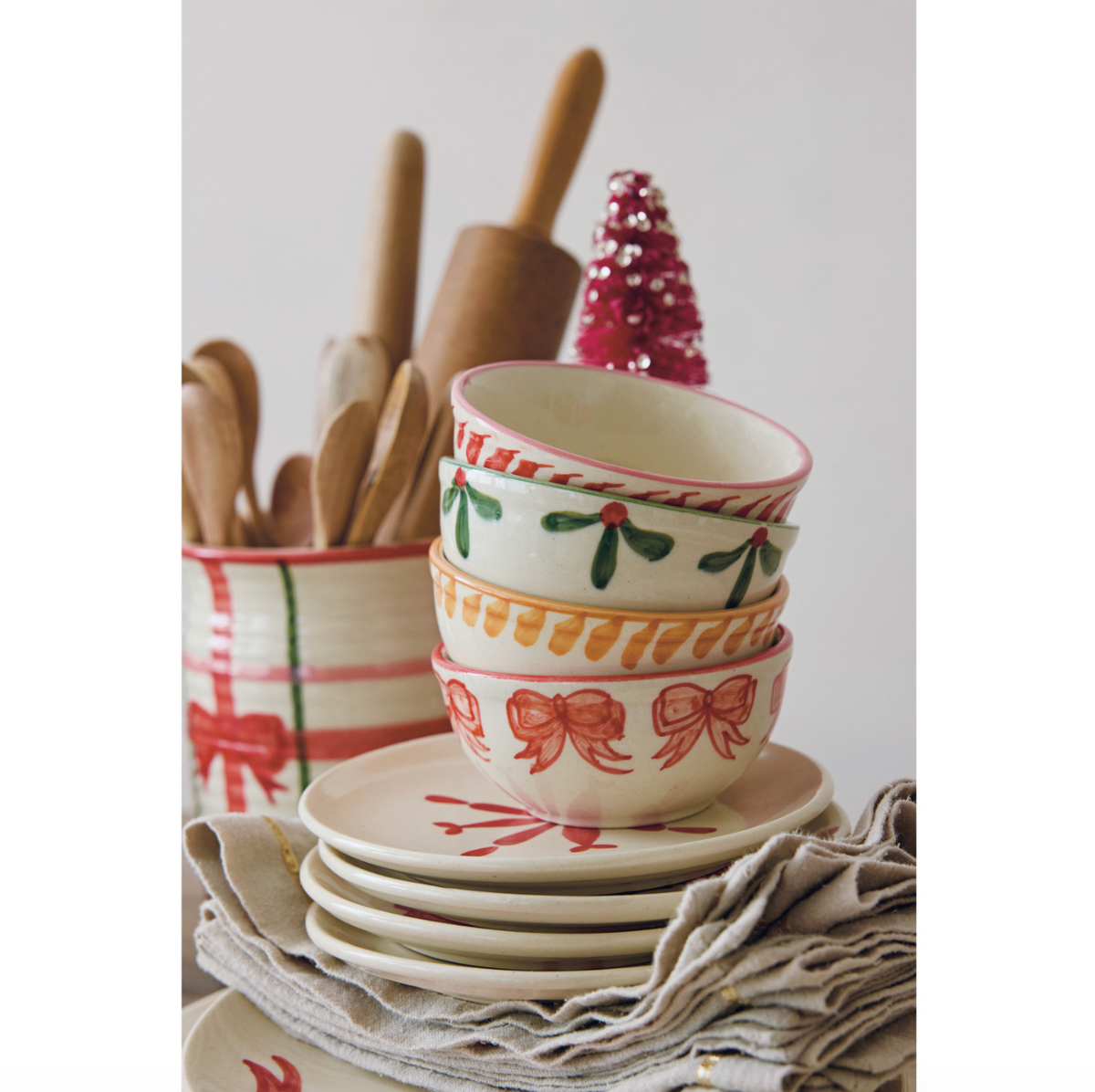 Stack of stoneware bowls with holly and bow motifs in red and green