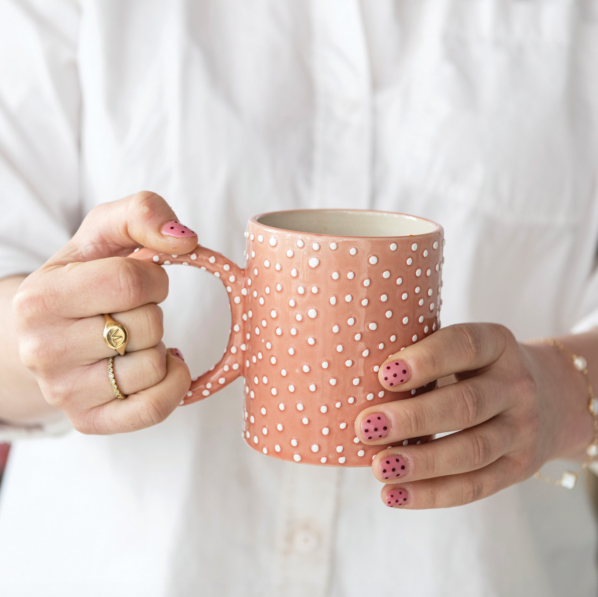 Pink ceramic mug with white polka dots and loop handle
