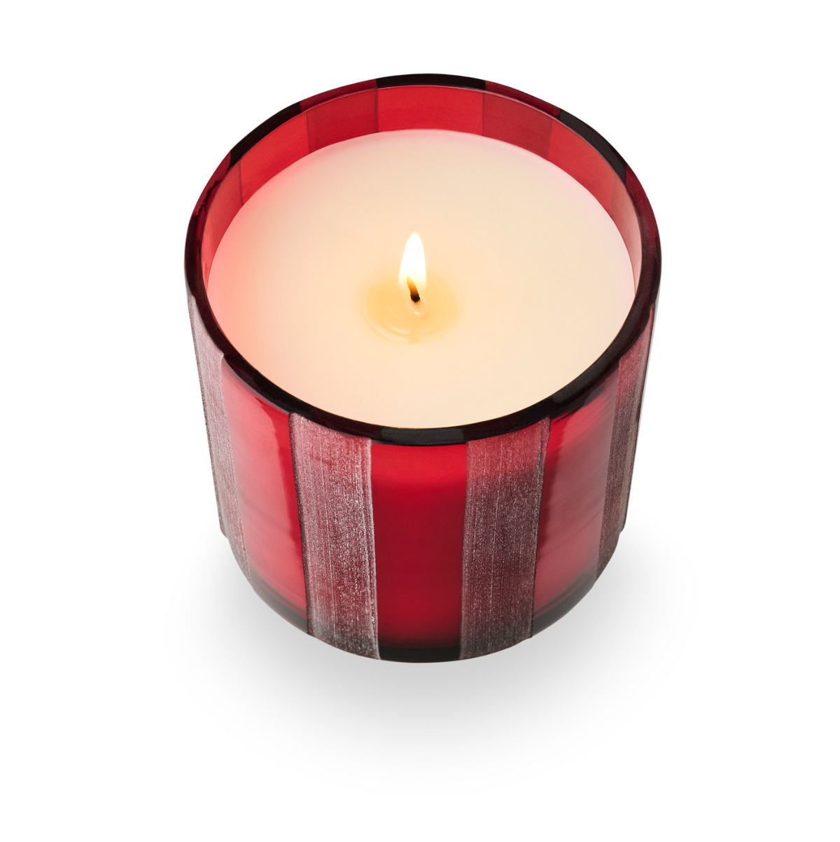 Red striped etched glass candle holder with flame and pale wax at top