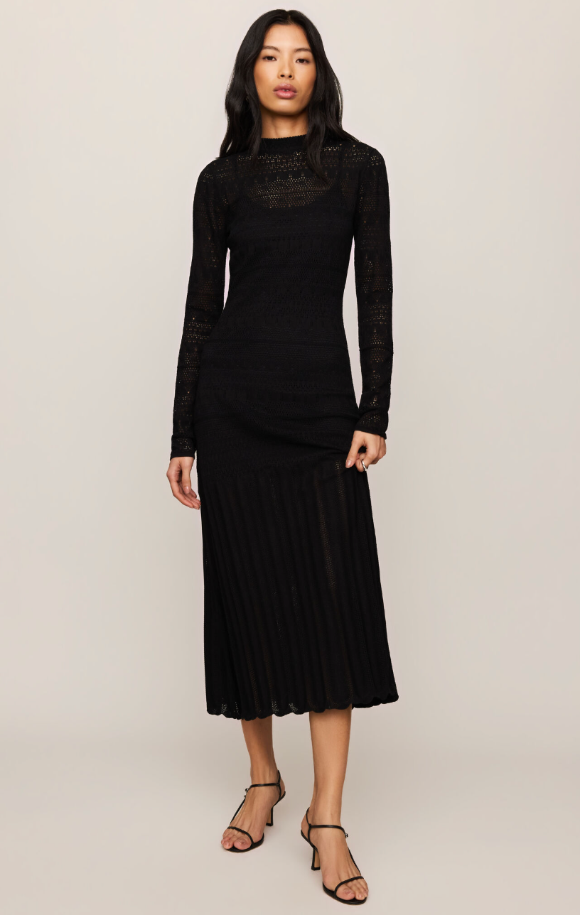 Black midi dress with high neck, long sheer sleeves, and pleated skirt