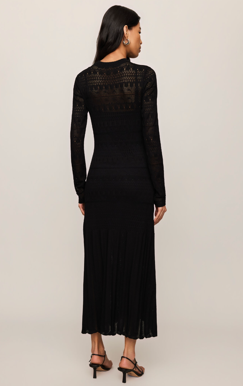 Black midi dress back view with high neck, long sheer sleeves, and pleated skirt