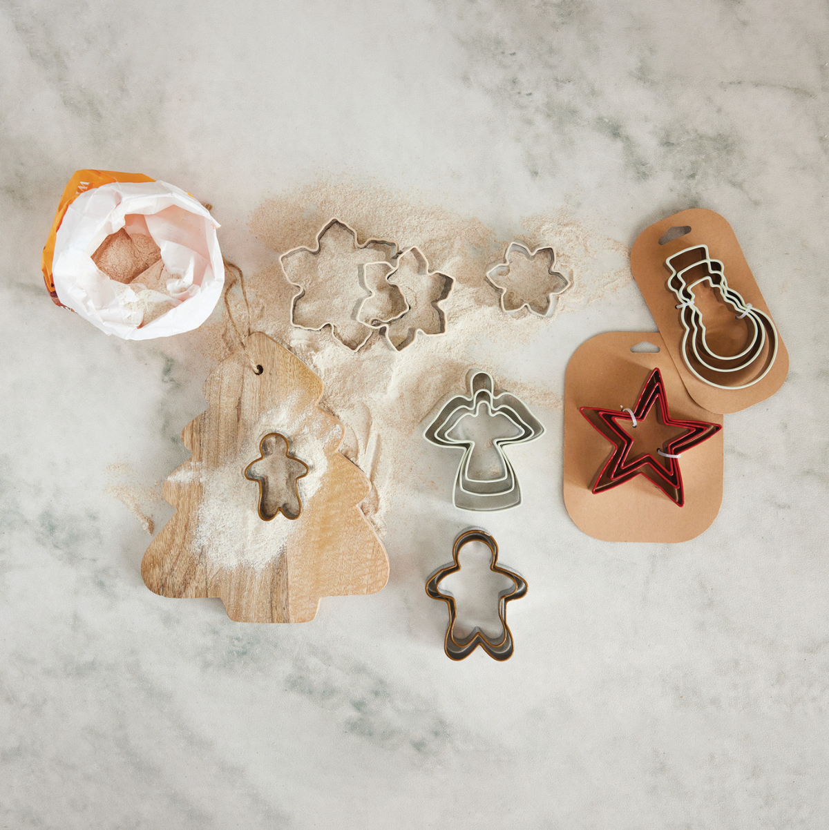 Holiday cookie cutters showing snowflake, star, snowman, gingerbread man, and angel outlines