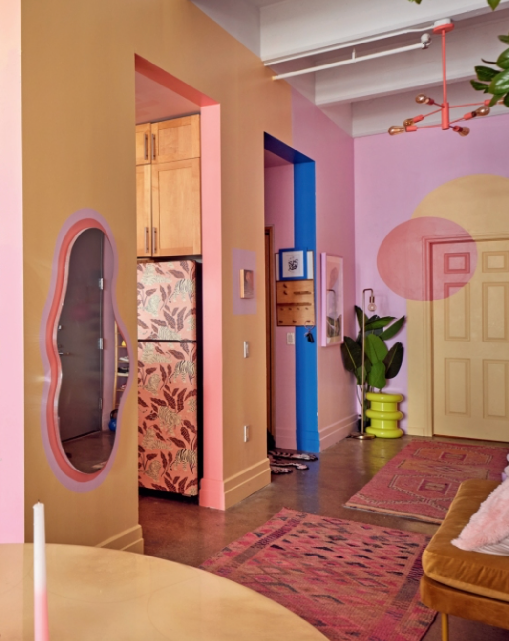 Colorful entry hallway with round mirror, console table, and patterned rugs