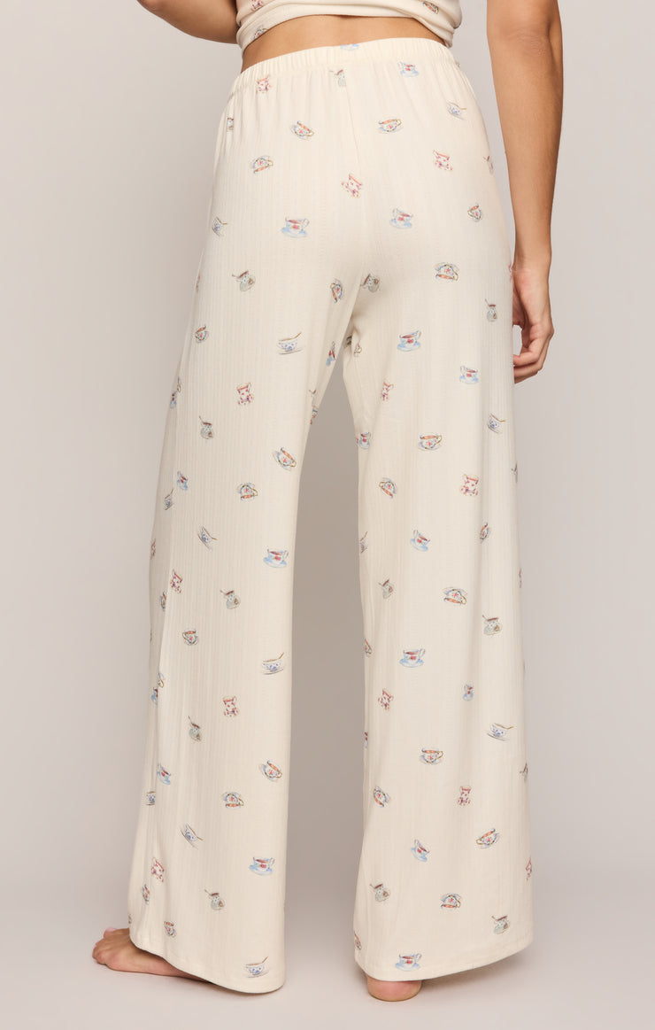 Cream wide-leg pajama pants featuring scattered tea cup and utensil motifs