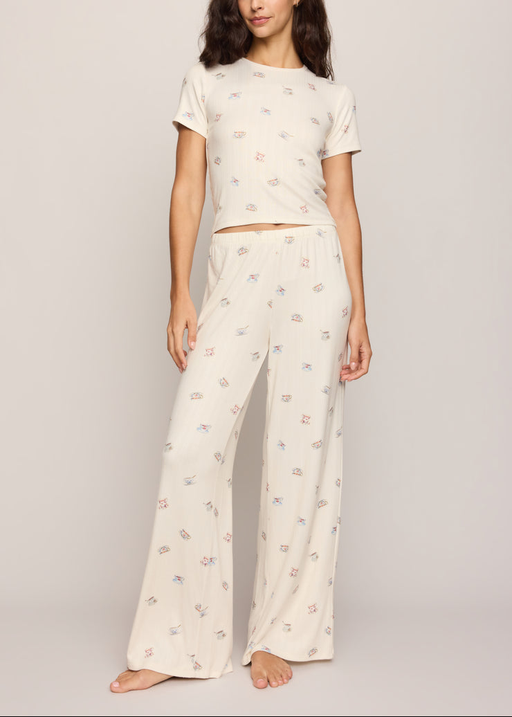 Cream pajama pants with full-length tea cup print and relaxed drape, elastic waist