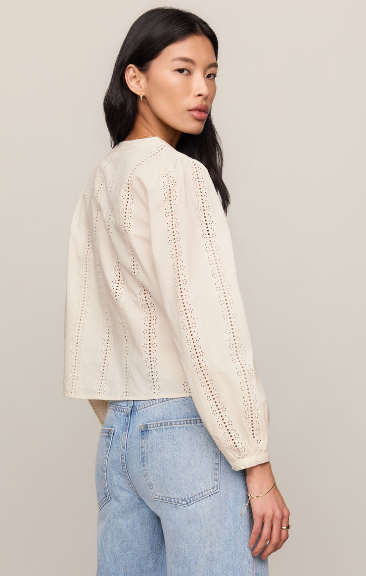 Off-white embroidered button-up top with V-neck and long puff sleeves, side view