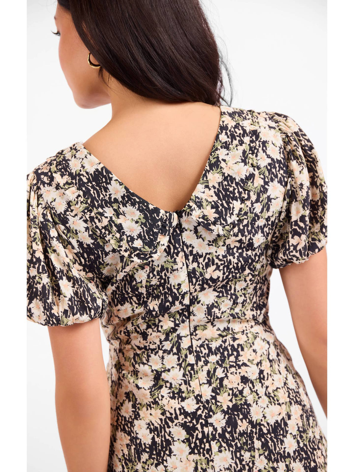 Back view of floral mini dress with tie-neck, puff sleeves and gathered seams