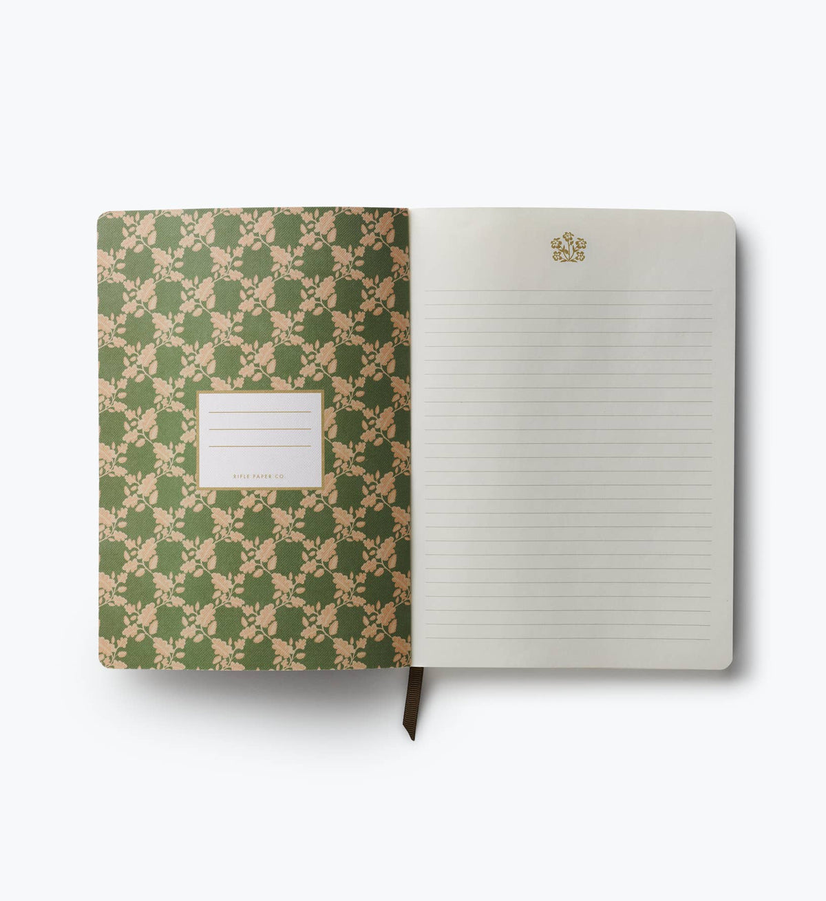 Open softcover journal with green floral cover and lined pages