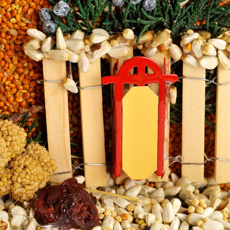 Seed-and-grain birdhouse ornament with red door and hedged roof trim