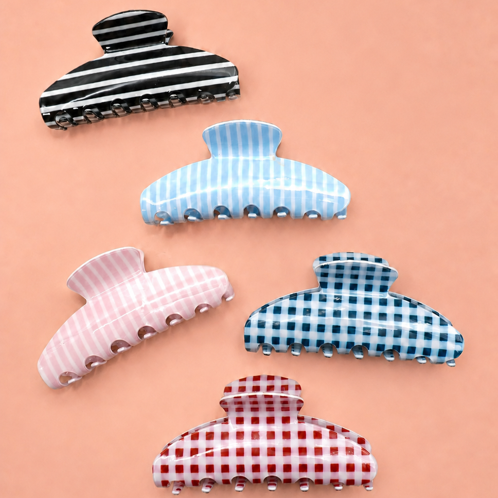 Black-and-white striped oval jumbo hair claw clip with ridged clasp teeth.