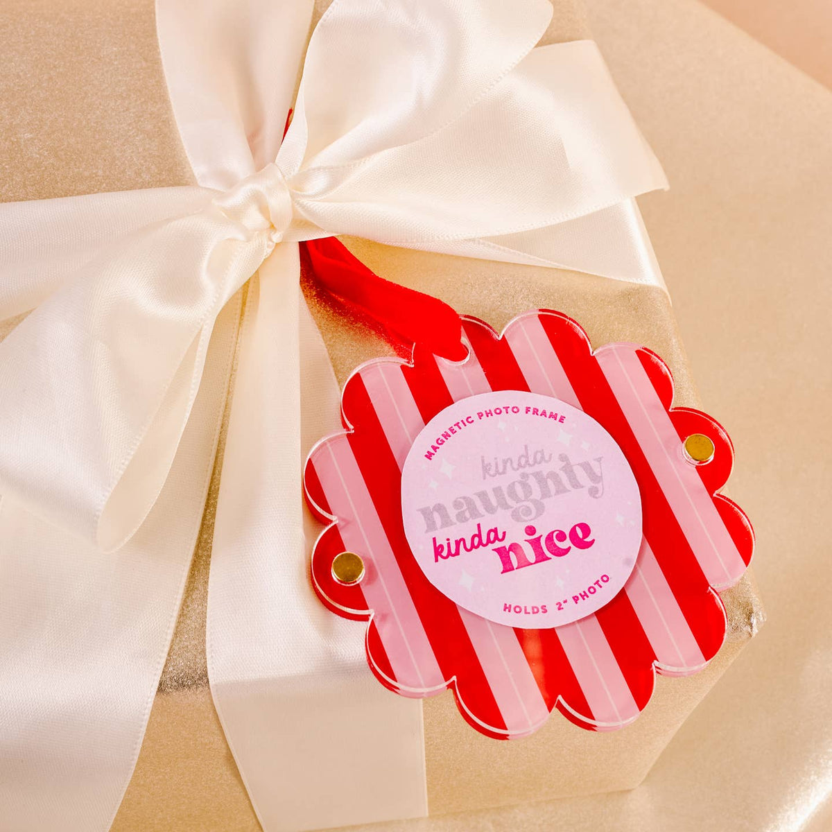 Peppermint striped scalloped magnetic photo frame ornament tied to a ribboned gift