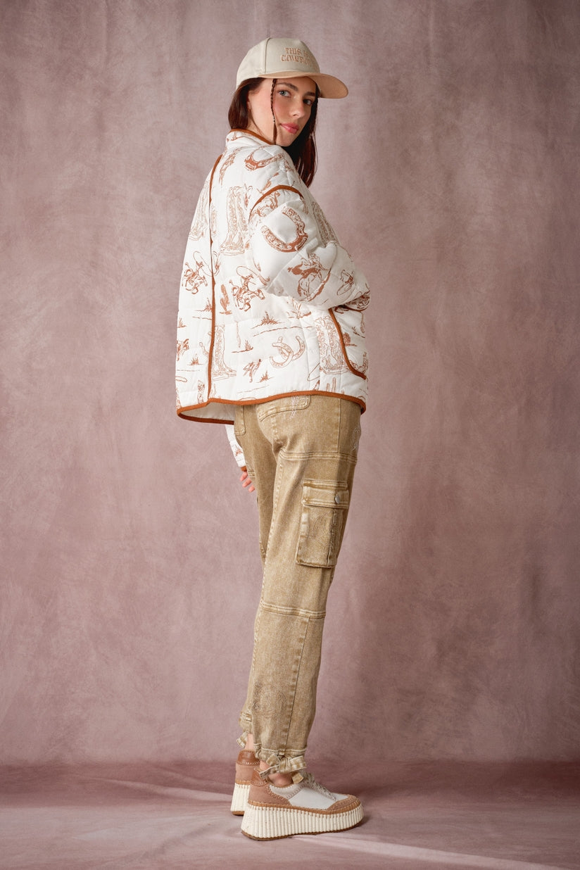Western quilted jacket profile view, white cowboy print with brown-trimmed edge and pocket