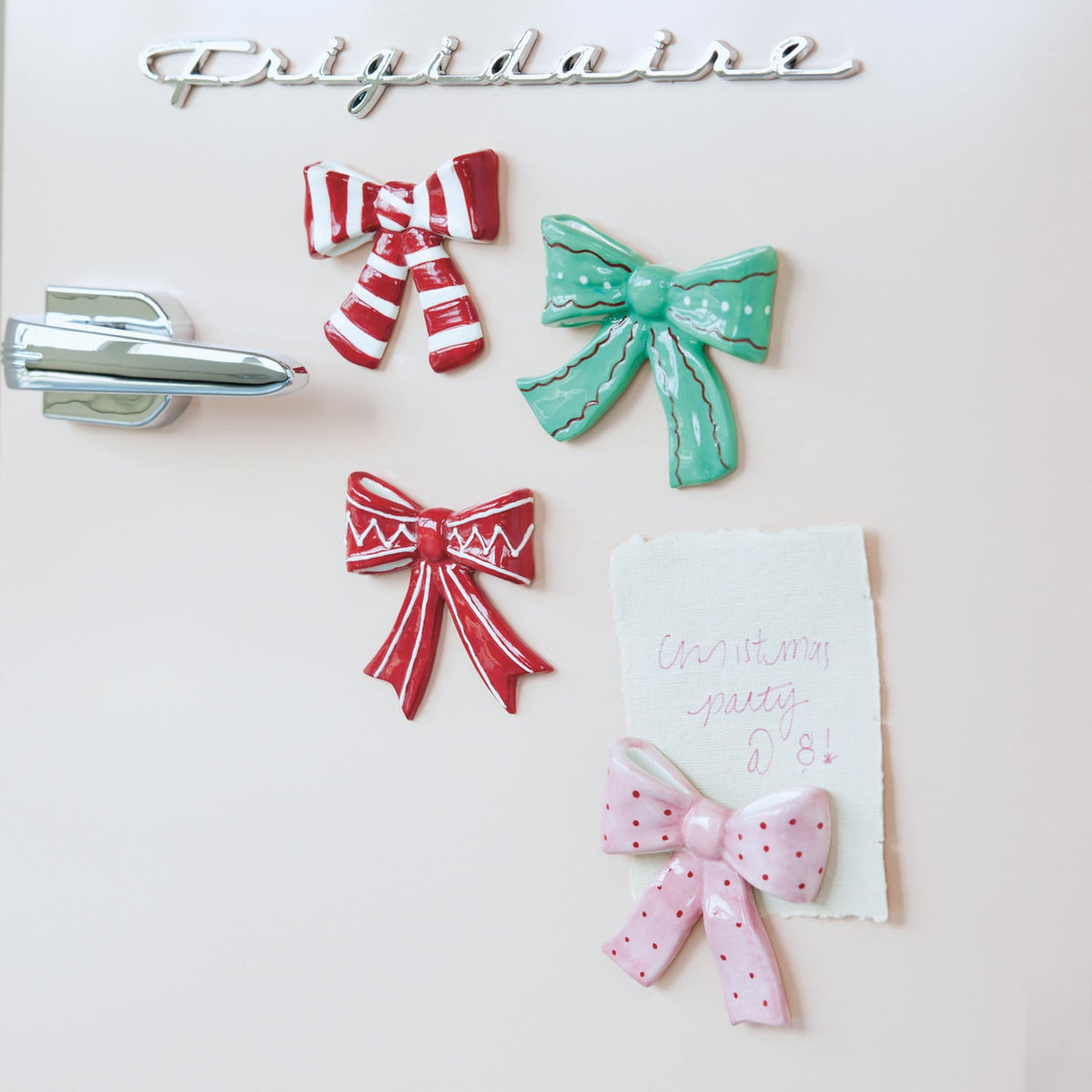 Assorted holiday bow magnets arranged, including red, green, and pink bow designs.