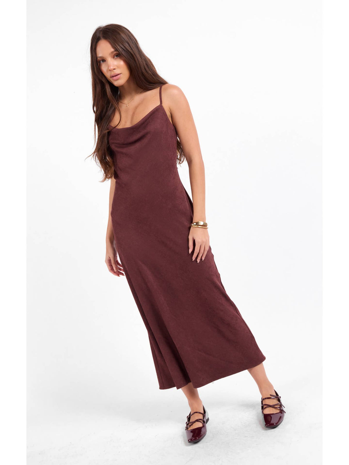 Burgundy sleeveless slip dress with spaghetti straps and fitted midi hem.
