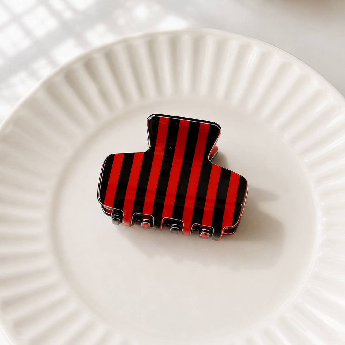 Striped hair claw clip with red and black vertical stripes