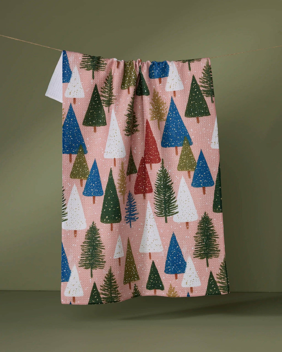 Pink tea towel with scattered pine tree print and hanging loop at top