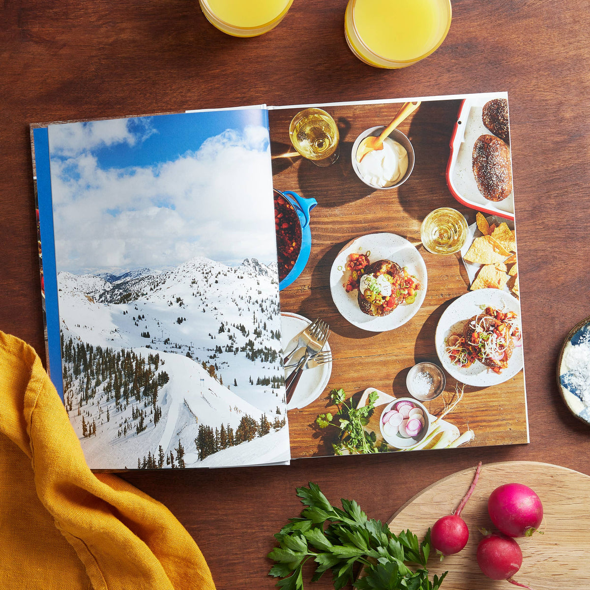 Open cookbook with snowy mountain photo and plated meal images