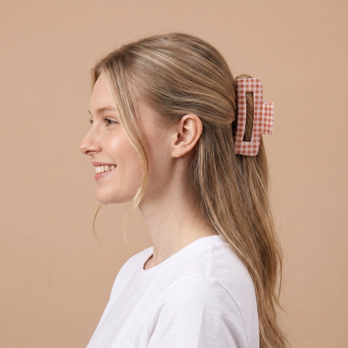 Orange-and-white gingham claw clip holding long hair in place