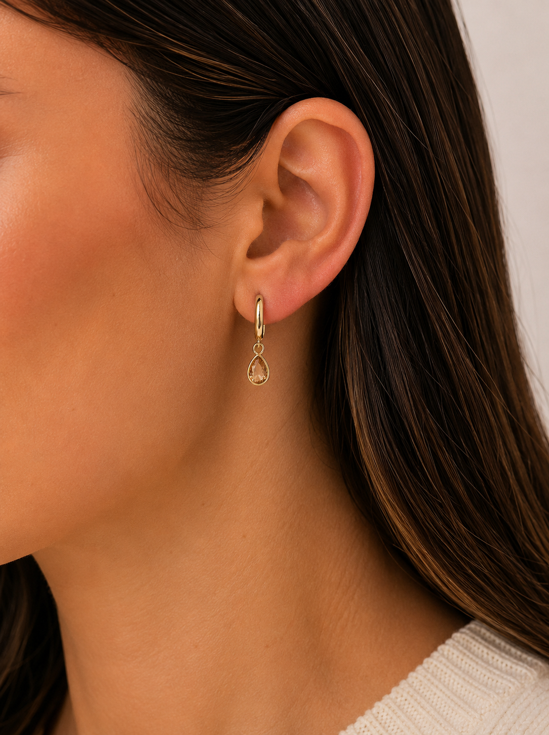 Gold teardrop CZ charm hoop earrings on ear, small dangling drop from hoops