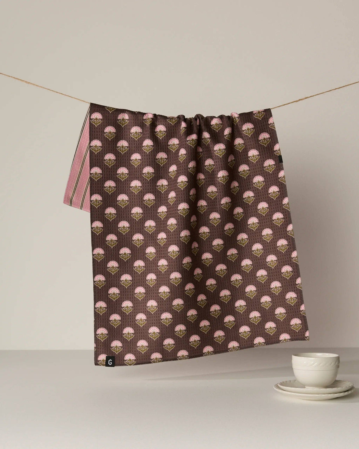 Brown kitchen towel with pink floral pattern and gathered top hem