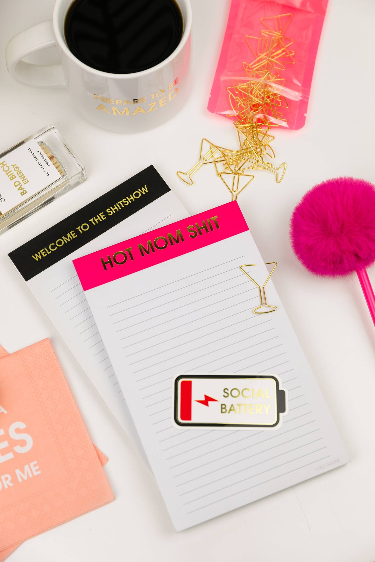 Gold martini glass paper clips scattered across notebooks and cards