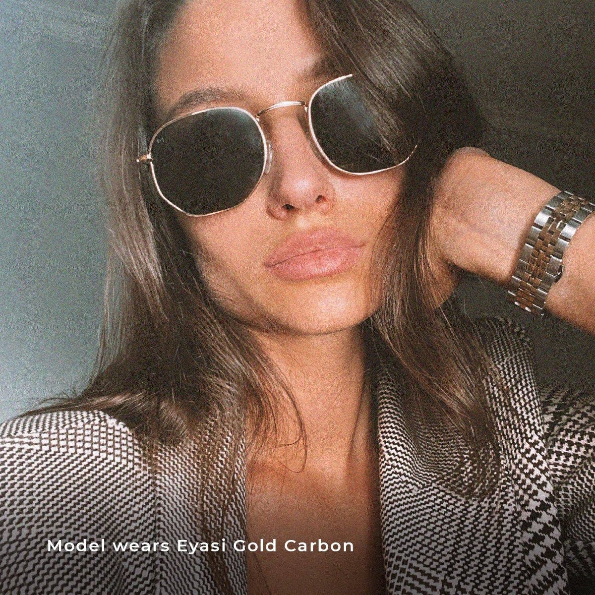 Gold-tone carbon sunglasses on a person, dark round lenses