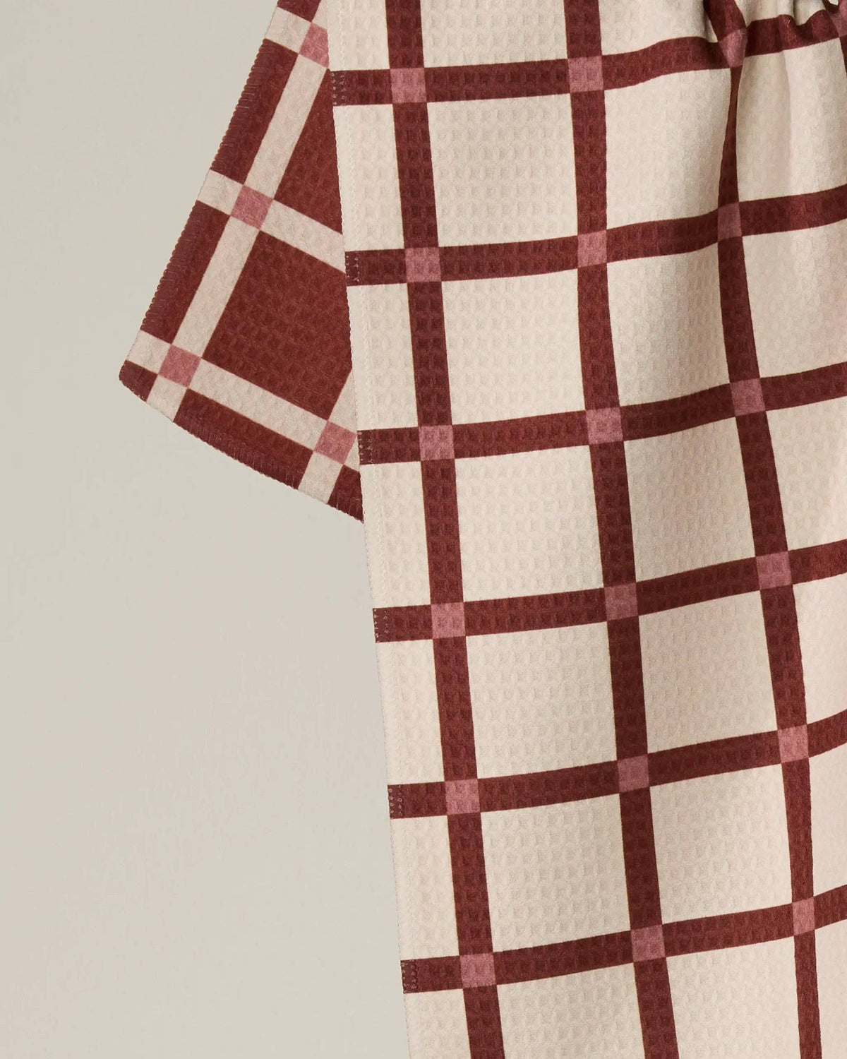Red and white checkered kitchen towel fabric close-up with waffle texture