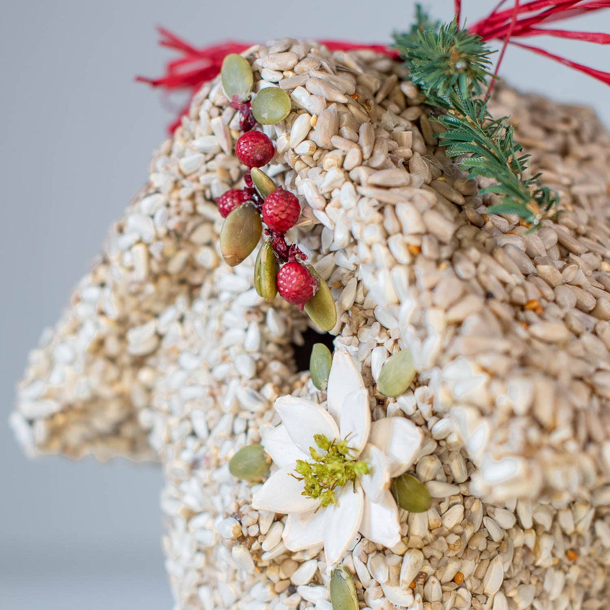 Seed birdie cottage ornament with white flowers, green leaves, red berries, and red hanger ribbon