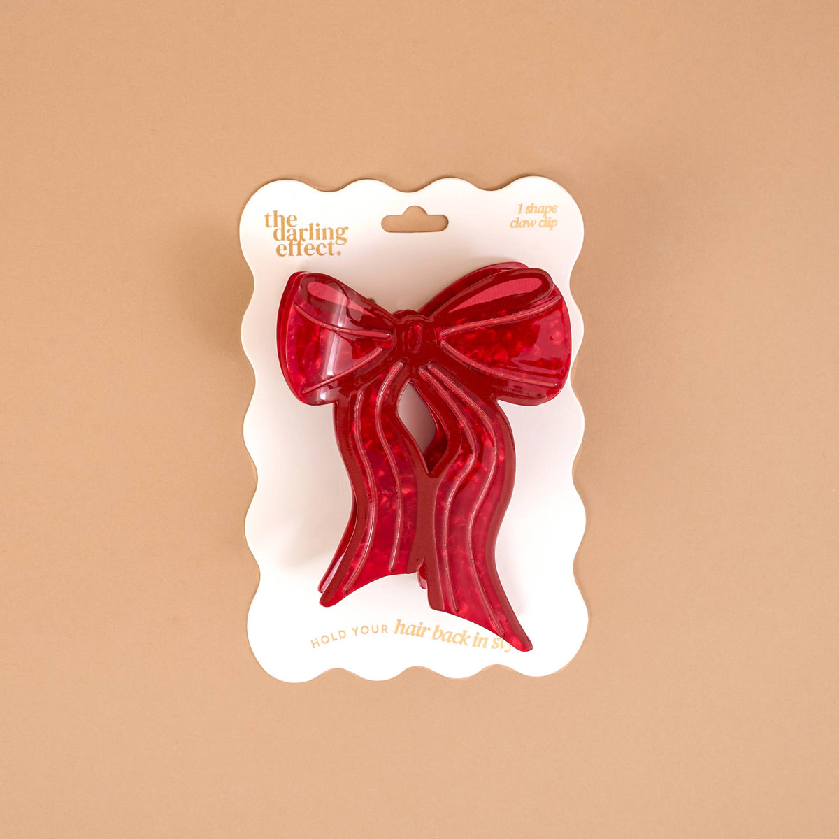 Red bow-shaped claw hair clip shown on a card package