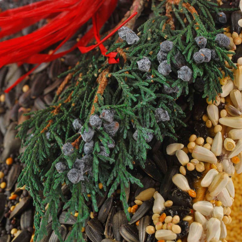 Decorative pine and berry arrangement with red ribbon and pinecones